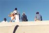 people on arch roof watching forest fire
